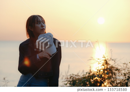 Twilight portrait of a woman gazing at the sunset Twilight portrait of a woman gazing at the sunset 133718580