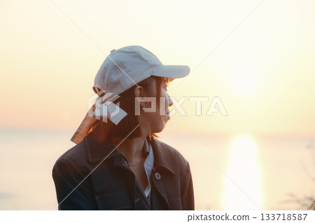 黃昏時分，一位女子凝視著落日。 133718587