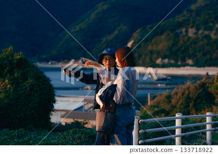 A twilight scene of a mother and daughter watching the sunset A twilight scene of a mother and daughter watching the sunset 133718922