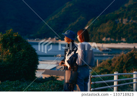 A twilight scene of a mother and daughter watching the sunset 133718923