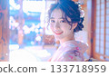 在柔和的光線下，一位身著振袖和服的年輕女子露出溫柔的微笑。 133718959