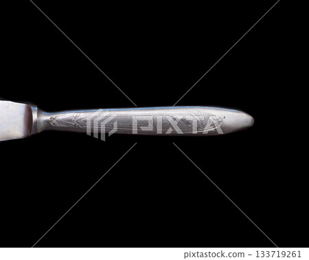 Metal knife handle on a black background. 133719261