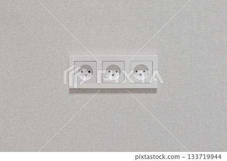 Three white outlets are on a white wall Three white outlets are on a white wall 133719944
