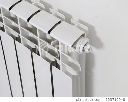 A white radiator with a white pipe attached to it 133719948