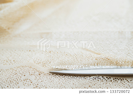 Cutting lace fabric with scissors 133720072