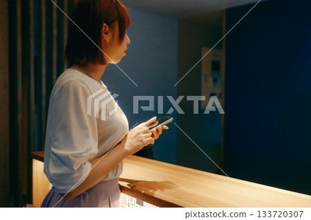 A woman in her twenties checking in with her smartphone A woman in her twenties checking in with her smartphone 133720307