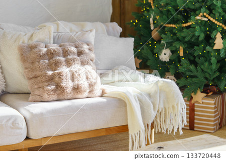 Cozy living room with decorated Christmas tree, warm sofa textiles and wrapped gifts for holidays Cozy living room with decorated Christmas tree, warm sofa textiles and wrapped gifts for holidays 133720448