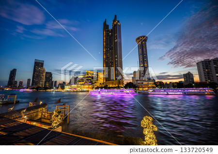 Modern buildings in the city with water reflection, firework, light show at twilight time. 133720549