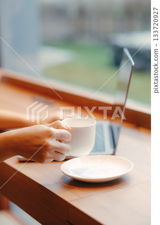 Laptop and coffee on a desk in a coworking space 133720927