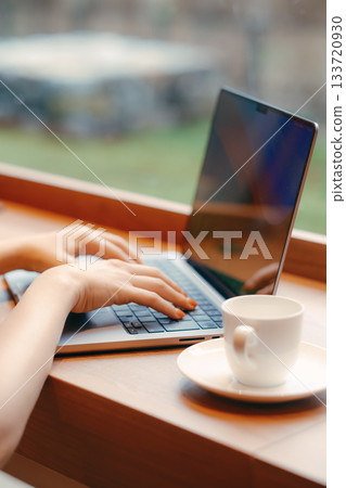 Laptop and coffee on a desk in a coworking space 133720930