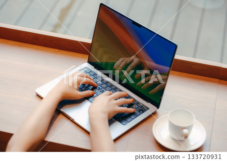 Laptop and coffee on a desk in a coworking space 133720931