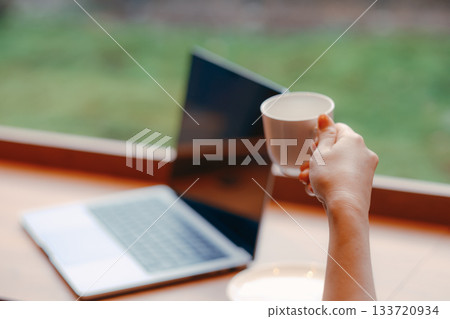 Laptop and coffee on a desk in a coworking space 133720934