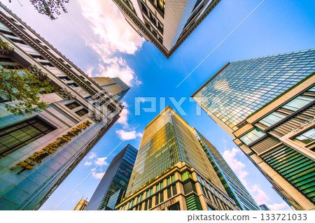 Tokyo cityscape in Japan. View of the skyscrapers of Nihonbashi bathed in the sunset and the redevelopment project of Nihonbashi 1-chome. Towards tomorrow, a new era. Tokyo cityscape in Japan. View of the skyscrapers of Nihonbashi bathed in the sunset and the redevelopment project of Nihonbashi 1-chome. Towards tomorrow, a new era. 133721033