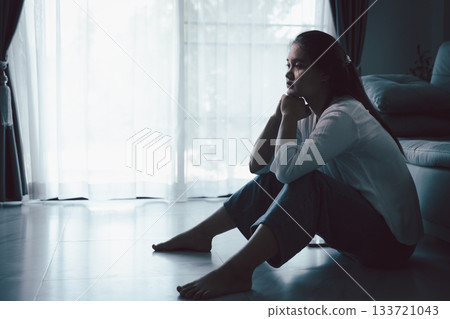 Tired depressed desperate tired girl sadly sitting on couch at home. Young woman is sitting on floor living room, feeling sad and depressed. Psychological problem. Depression and loneliness concept. Tired depressed desperate tired girl sadly sitting on couch at home. Young woman is sitting on floor living room, feeling sad and depressed. Psychological problem. Depression and loneliness concept. 133721043