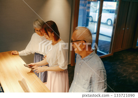 A scene where three parents and children check in at a hotel 133721090