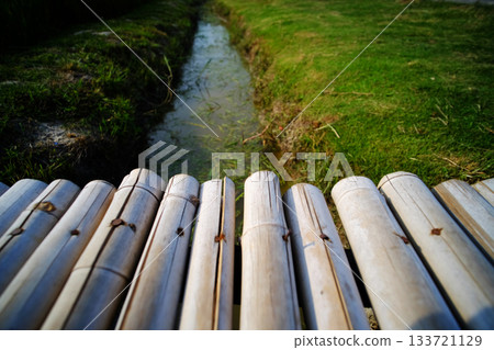 Wooden bamboo bridge across watercourse rice field 133721129