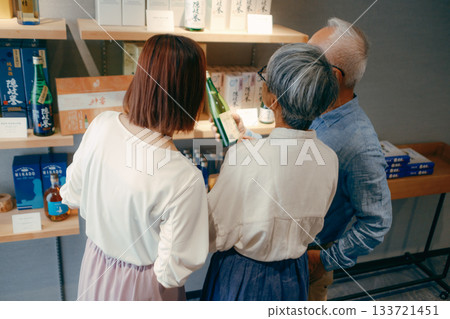 一家三口在飯店店挑選紀念品的場景 133721451