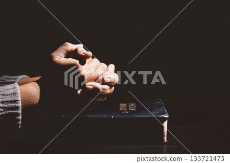Hands clasped in prayer over the Holy Bible, symbolizing faith, devotion, Christianity, hope and spiritual strength through God Word, worship, meditation and encouragement. Hands clasped in prayer over the Holy Bible, symbolizing faith, devotion, Christianity, hope and spiritual strength through God Word, worship, meditation and encouragement. 133721473
