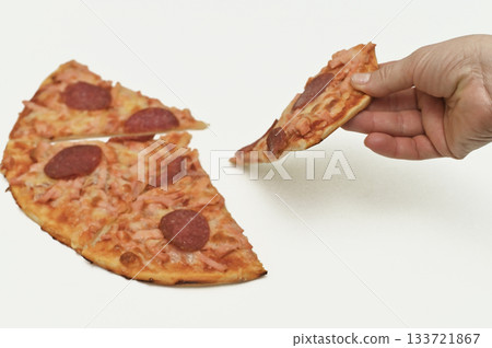 Hands pulling apart a slice of pizza with pepperoni, showcasing the cheesy stretch and delicious toppings. The pizza slice is fresh and savory. on a white background. Hands pulling apart a slice of pizza with pepperoni, showcasing the cheesy stretch and delicious toppings. The pizza slice is fresh and savory. on a white background. 133721867