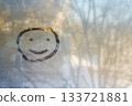 Single happy face drawn on fogged glass radiates pure joy through water droplets. Temporary smiley grins through office glass. cheerful smile is concept of good mood. 133721881