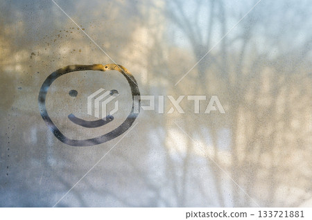 Single happy face drawn on fogged glass radiates pure joy through water droplets. Temporary smiley grins through office glass. cheerful smile is concept of good mood. Single happy face drawn on fogged glass radiates pure joy through water droplets. Temporary smiley grins through office glass. cheerful smile is concept of good mood. 133721881