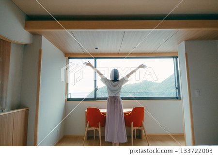 A scene of a woman in her twenties looking at the spectacular view from a hotel room A scene of a woman in her twenties looking at the spectacular view from a hotel room 133722003