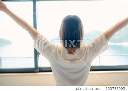 A scene of a woman in her twenties looking at the spectacular view from a hotel room 133722005