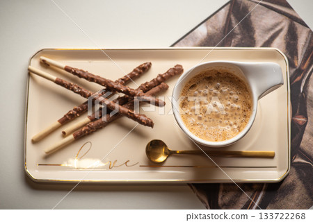 Delicious Snack Pairing: Breadsticks and Coffee on a Plate 133722268