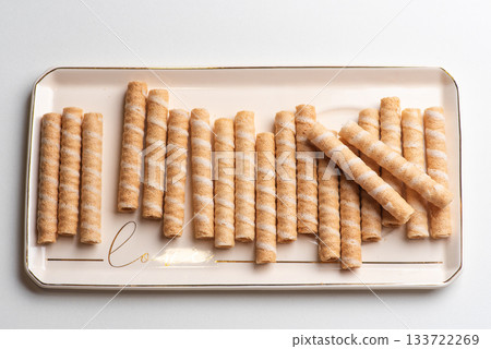 Crunchy Wafer Rolls Neatly Arranged on Decorative Plate 133722269