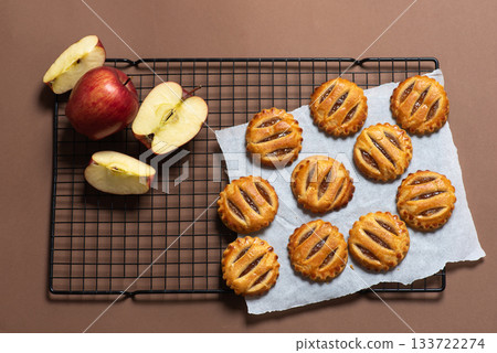 Freshly Baked Apple Cookies on Wire Rack with Sliced Apples Nearby Freshly Baked Apple Cookies on Wire Rack with Sliced Apples Nearby 133722274