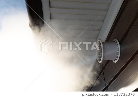 white vapor escapes under cabin roof, frosty air encounters warm sauna steam outside wooden shelter white vapor escapes under cabin roof, frosty air encounters warm sauna steam outside wooden shelter 133722376