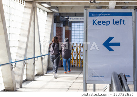 Keep Left Sign with Blue Arrow Directing Pedestrians in Urban Walkway Keep Left Sign with Blue Arrow Directing Pedestrians in Urban Walkway 133722655