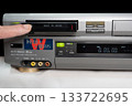 A scene of inserting a tape into a worn Hi8 VCR 133722695
