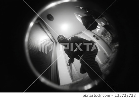 Nighttime camera detects cautious individual, Fisheye lens captures elusive figure on porch, Mysterious person under blue illumination recorded by fisheye security camera 133722728