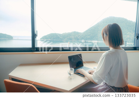 一位二十多歲的女性在飯店房間裡使用電腦的場景 一位二十多歲的女性在飯店房間裡使用電腦的場景 133723035