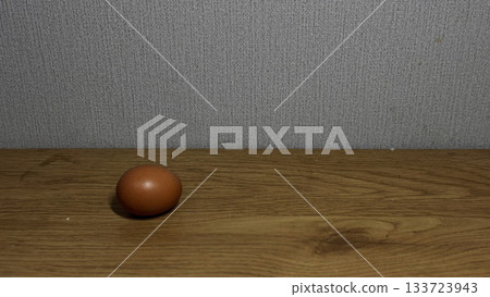 Fresh Brown Egg on Wooden Table with Neutral Background 133723943
