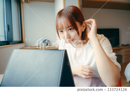A woman in her 20s looking in the mirror in a hotel room and adjusting her appearance | Travel, accommodation, makeup A woman in her 20s looking in the mirror in a hotel room and adjusting her appearance | Travel, accommodation, makeup 133724126