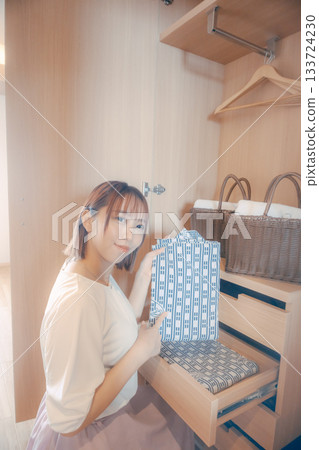 一位二十多歲的女性在飯店房間裡挑選浴衣的場景 一位二十多歲的女性在飯店房間裡挑選浴衣的場景 133724230