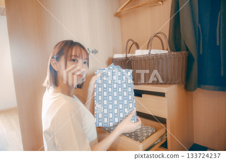 一位二十多歲的女性在飯店房間裡挑選浴衣的場景 133724237