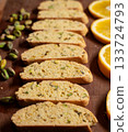 Soft focus image of biscotti cookies, lined by pistachio nuts and orange slices, classic holiday flavors 133724793