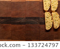 Four orange and pistachio biscotti cookies placed at the upper right of the image, with a wood background and copy space 133724797