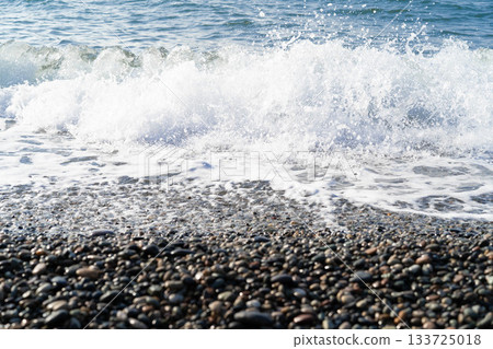 A wave splashes against the shore of the sea of pebbles and the horizon connects the sea and the sky. Great layout for your ads. A wave splashes against the shore of the sea of pebbles and the horizon connects the sea and the sky. Great layout for your ads. 133725018
