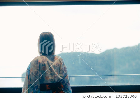 一位二十多歲的女子身穿浴衣，靜靜地凝望著大海。 133726306