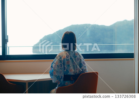 A scene of a woman in her twenties in a yukata standing quietly gazing at the sea A scene of a woman in her twenties in a yukata standing quietly gazing at the sea 133726308