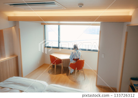 一位二十多歲的女子身穿浴衣，靜靜地凝望著大海。 133726312