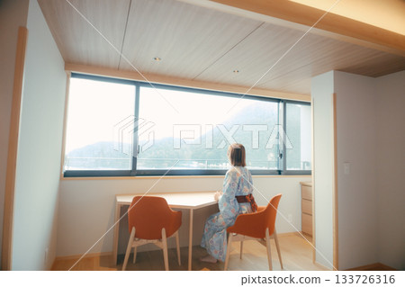 一位二十多歲的女子身穿浴衣，靜靜地凝望著大海。 133726316