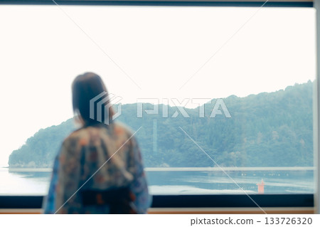 一位二十多歲的女子身穿浴衣，靜靜地凝望著大海。 133726320
