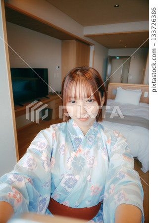 A scene of a woman in her 20s in a yukata taking a selfie in a guest room A scene of a woman in her 20s in a yukata taking a selfie in a guest room 133726386