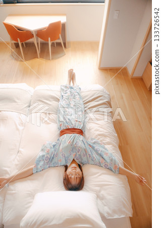 一位身穿浴衣的女子在床上放鬆的場景 133726542