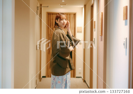 一位身穿浴衣的女子在日式旅館的走廊回頭望去。 一位身穿浴衣的女子在日式旅館的走廊回頭望去。 133727168